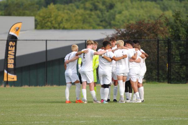 a group of men's soccer players in white uniforms on the field